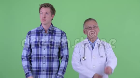 快乐成熟的日本男医生和年轻人在一起思考视频的预览图