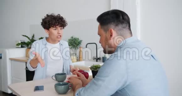 不高兴的妻子在厨房吃早餐时和丈夫打架打手势视频的预览图