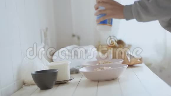 白色木桌上有薄煎饼和水果沙拉切割的粉红色碗不可辨认的女人放了酸奶油视频的预览图