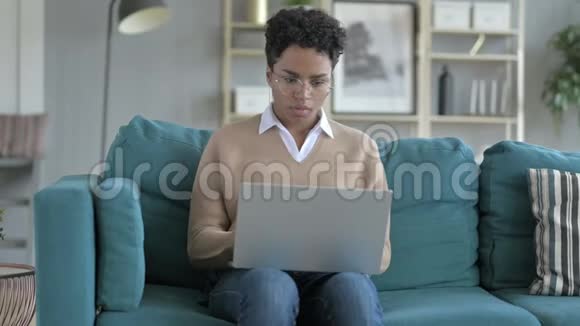 年轻的非洲女孩坐在沙发上穿衣打扮视频的预览图