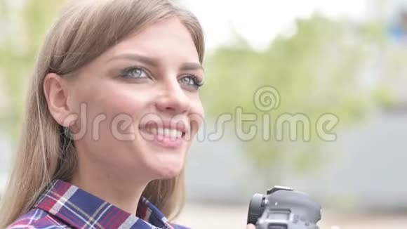 美丽的女摄影师在相机中微笑视频的预览图