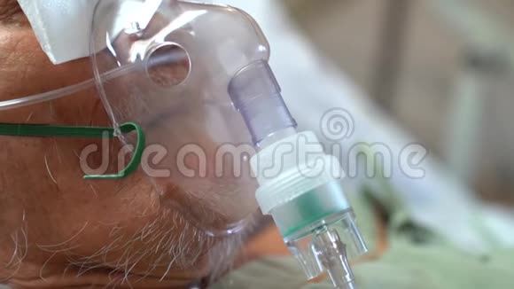 这位老人正在通过氧气罩吸入药物以扩大支气管从而治愈呼吸系统视频的预览图