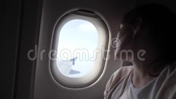 昏昏欲睡的疲惫的女人的肖像正在看飞机窗口的迪龙飞行视频的预览图
