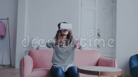 未来就是今天快乐的年轻女子在家里测试虚拟现实眼镜她一边移动一边转身视频的预览图
