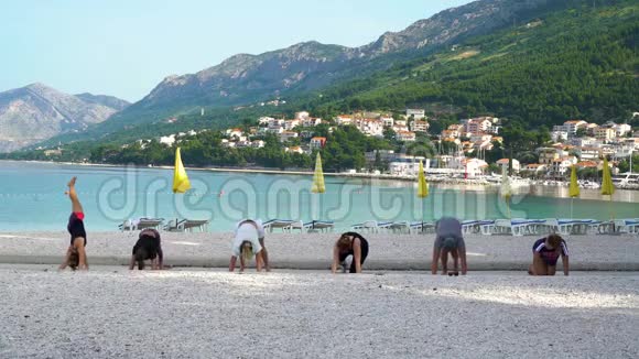 早上一群人在美丽的亚得里亚海海滨练习瑜伽视频的预览图