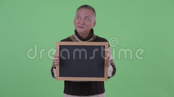 快乐成熟的日本男人拿着黑板思考视频的预览图