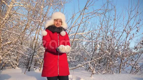 幸福的女孩在森林里日落时双手举起雪雪在阳光下落下闪闪发光漂亮少女视频的预览图