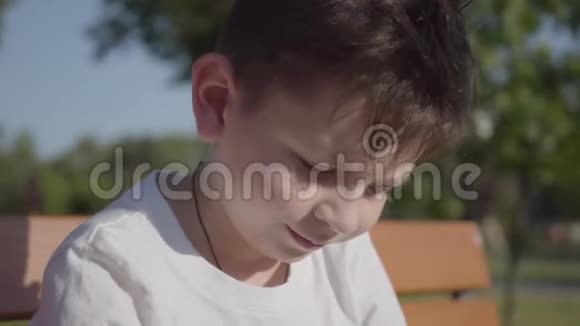户外一个可爱的微笑男孩的肖像可爱的孩子花时间在夏天的公园里视频的预览图