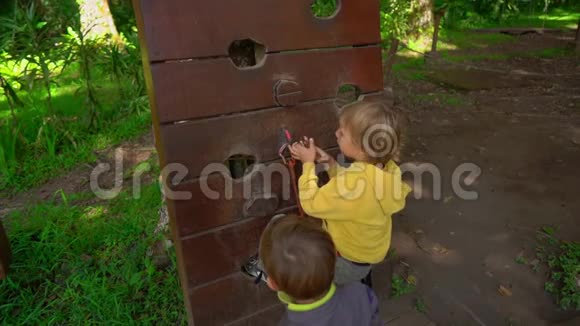 在森林探险公园里两个穿着安全装备的小男孩慢镜头室外娱乐中心视频的预览图