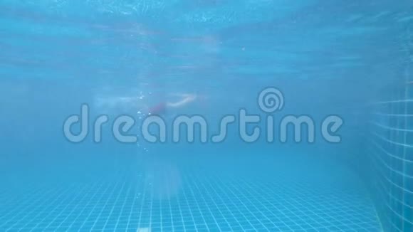 少年男孩在游泳池里游泳手上拿着气囊学习游泳从水下看到的景色视频的预览图