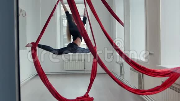 苗条的女钢管舞者用空中丝绸做麻绳视频的预览图