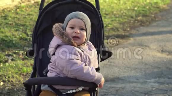 戴着灰色帽子的Toddlr婴儿坐在婴儿车里哭讨厌婴儿车4k视频的预览图