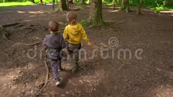 在森林探险公园里两个穿着安全装备的小男孩慢镜头室外娱乐中心视频的预览图