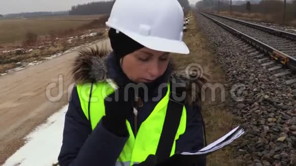女铁路工程师在铁路附近写作和思考视频的预览图