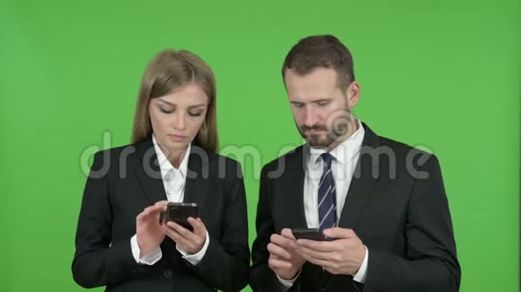 男性和女性商业专业人员使用智能手机对抗色度键视频的预览图