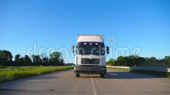 在夏季公路上运输货物的卡车和货物拖车的正面视图白色货车穿过视频的预览图