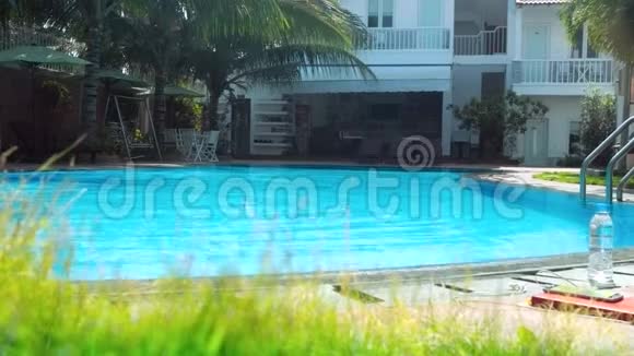 女孩沿着酒店游泳池游到障碍和倾斜视频的预览图