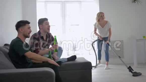 男朋友在沙发上坐着啤酒看足球女朋友带着吸尘器然后给每个人视频的预览图