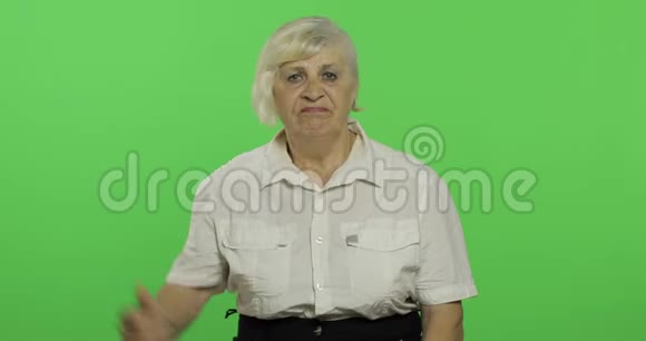 一位年长的女人拒绝了并把她的拇指放下奶奶铬键视频的预览图