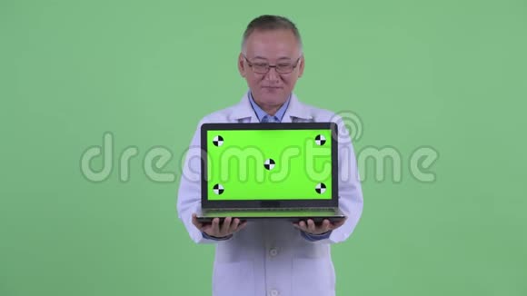 快乐成熟的日本男医生在讲手提电脑视频的预览图