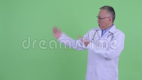 快乐成熟的日本男医生在展示东西时看起来很兴奋视频的预览图