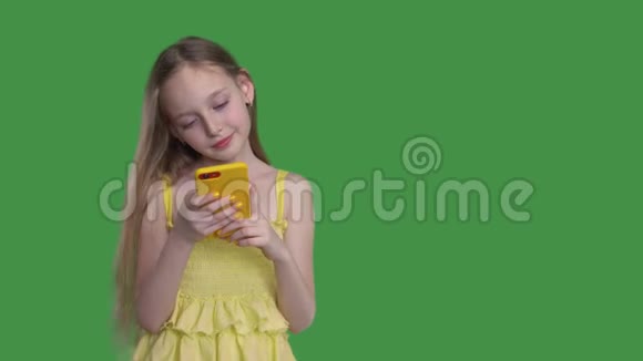 青少年女孩在透明的绿色背景下使用手机少女长发随风飘扬视频的预览图