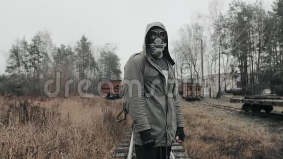 戴着防毒面具的人站在废弃的火车站世界末日概念视频的预览图