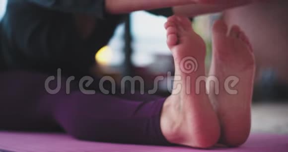 细节特写女士的脚和手她在早上在家伸展身体瑜伽练习练习视频的预览图