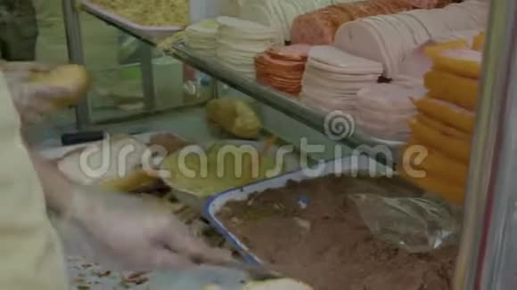 一个小贩把肉放进面包里做三明治视频的预览图