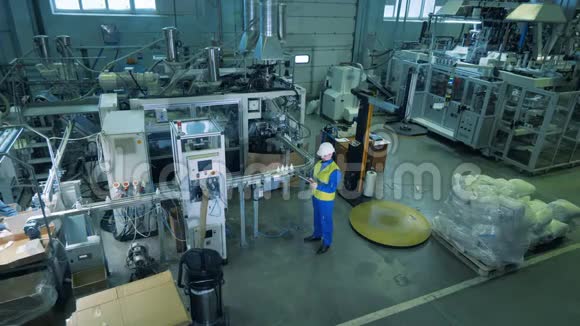 一家生产塑料容器的工厂的大型单位里面有一名男工视频的预览图