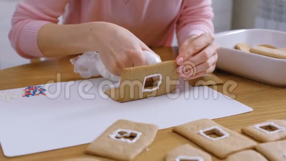 女人手做姜饼屋的细节与糖甜糖霜烹饪自制姜饼屋视频的预览图
