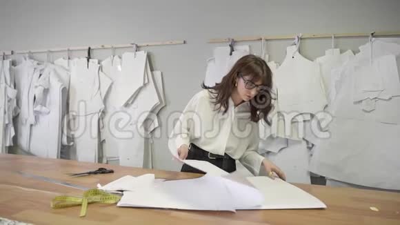 时装设计师挑选纸样挂在缝纫室里视频的预览图