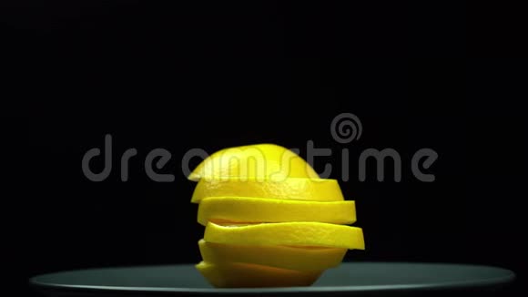 在黑色背景的盘子上旋转的黄橙色视频的预览图