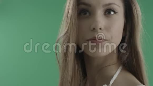 绿色背景下头发蓬松的迷人年轻女子视频的预览图