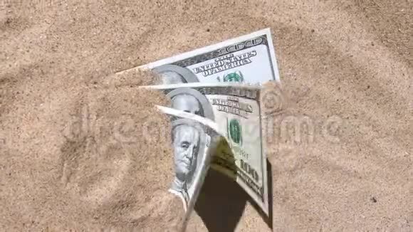 钱娃娃一半被沙子覆盖在海滩上视频的预览图