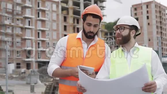 建筑工地的建筑工人和建筑师用平板电脑拍照并与施工计划核对视频的预览图