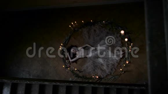 仪式祭祀或挑战精神苗条的女孩躺在一圈蜡烛和树枝上她是个处女视频的预览图