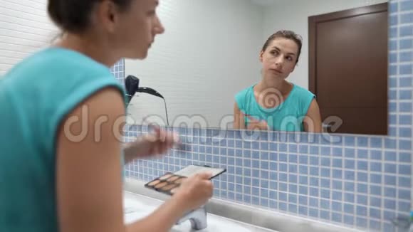 美女在浴室镜子前做面部轮廓视频的预览图
