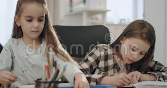 两个欧洲小女孩和他们成熟的母亲在做家庭作业时在一起度过美好时光的肖像视频的预览图