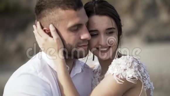 一对年轻的新婚夫妇的性感肖像一个微笑的女孩和一个闭着眼睛的男人模糊的背景行动视频的预览图