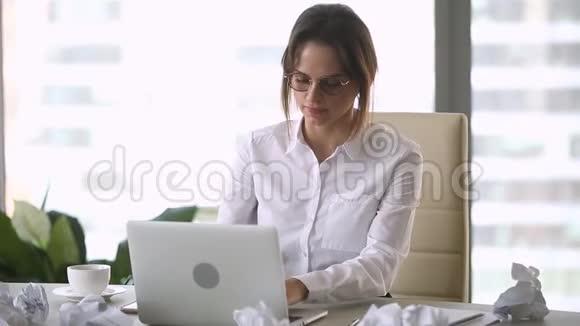女作家把皱巴巴的纸扔在卡住的笔记本电脑上视频的预览图