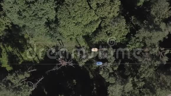 一辆缆车在夏季的一个晴朗的日子里在绿色森林上行驶的空中俯视图哈尔科夫乌克兰视频的预览图
