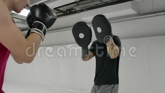 拳掌的威力强壮的纹身运动员在运动服训练中与同伴一起练习拳击爪子视频的预览图