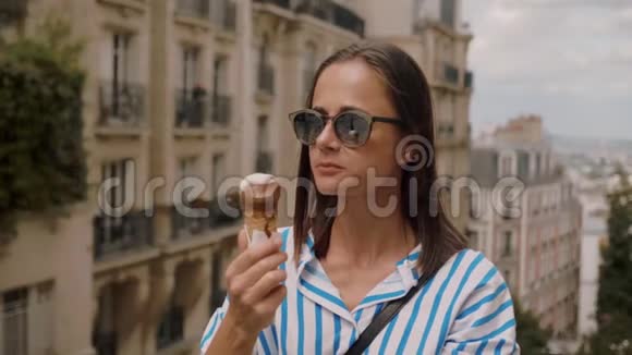 快乐的女孩在巴黎炎热的夏日舔冰淇淋视频的预览图