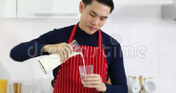 亚洲人把牛奶倒入玻璃杯里喝视频的预览图