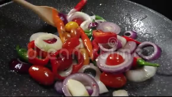 厨师用平底锅烤蔬菜用木勺搅拌视频的预览图
