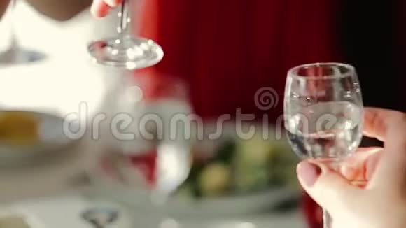 人们举起香槟酒杯叮当作响的酒杯做烤面包在餐桌上喝酒近距离观看朋友家人视频的预览图