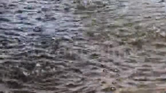 雨滴落下发出涟漪天空在黑暗的水中反射天气背景图视频的预览图