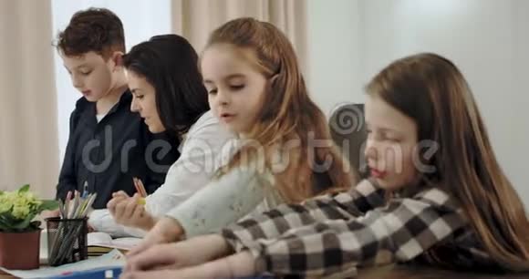 有魅力的孩子和他们成熟的母亲一起做作业一起度过美好时光的画像视频的预览图