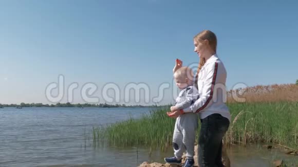 家庭户外娱乐活动节日期间带着小男孩的幸福女人把食物扔进水中捞鱼视频的预览图